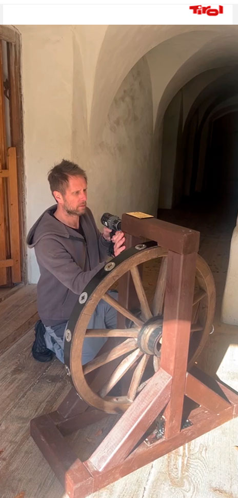 A person in a traditional outfit playing a drum in an escape room, enhancing the atmosphere and experience, just as described in the collaboration with Just Escape Consulting.